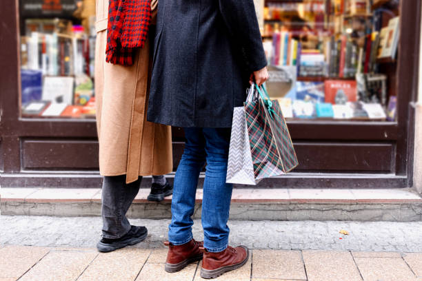 Young couple with shopping bags looking at window display