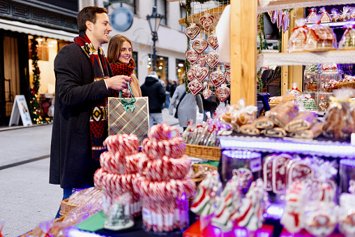 Couple buying during Christmas market at market souvenir shop stall