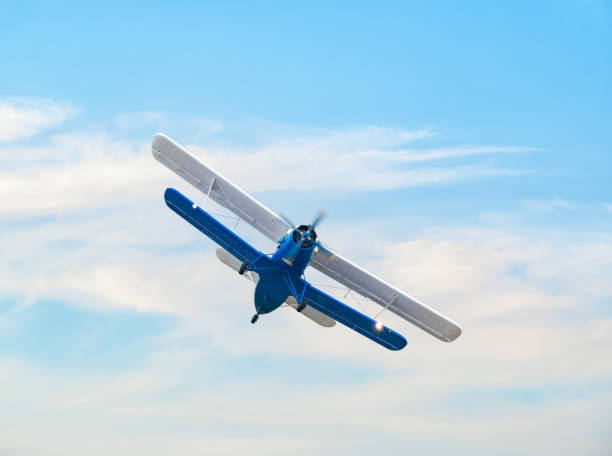 Bucharest, Romania - September 2022: A soviet Antonov An-2 single-engine biplane flying against blue sky.