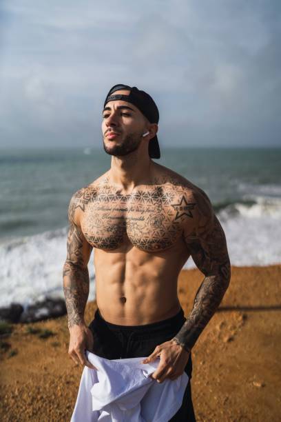 istock Topless Caucasian man from Spain with tattoos posing in a beach 1449622240