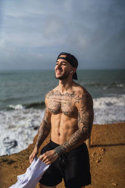 istock Topless Caucasian man from Spain with tattoos posing in a beach 1449622243