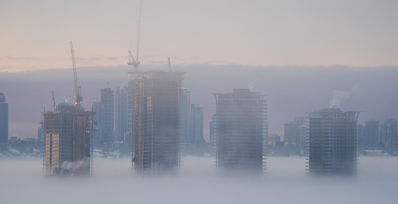 Burnaby, British Columbia, Canada - December 5, 2022: A thick fog blanket covering the skyline of Metro Vancouver on a winter morning during sunrise.