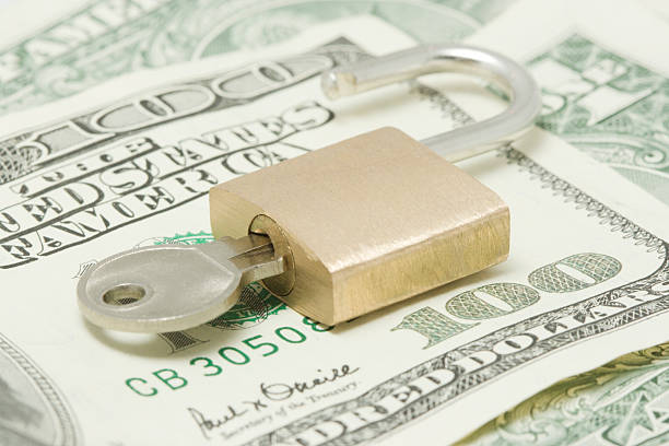 istock Opened padlock with key on top of hundred dollars bill 144963386