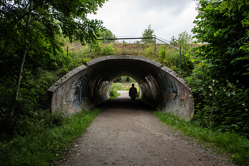 Gothenburg, Sweden - July 11 2021: Person passing through an underpass under a railway line.