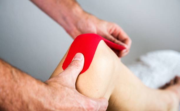 istock Caucasian hands putting Tape on knee, physical therapy, 1449636542