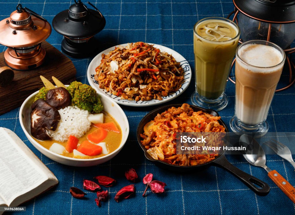 Assorted Aw Vegetable Curry, Grilled Spicy Chow Mein, Fried Instant Noodles with Fried Sauce, latte, Matcha Coffee Latte served in dish isolated on table top view of taiwan food Coffee - Drink Stock Photo