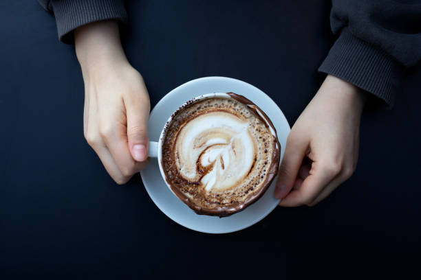 istock woman holding a cup of coffee 1449638691