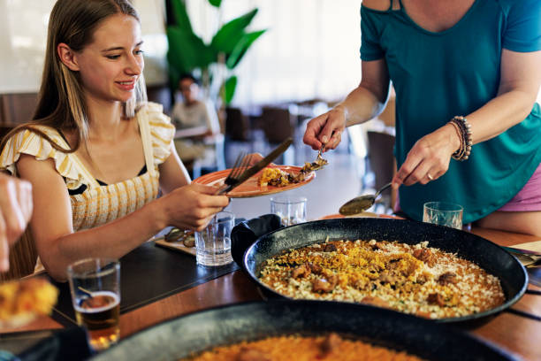 Mother and daughter having delicious paella dinner.\nCanon R5