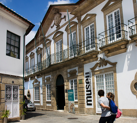 Penafiel, Portugal- May 3, 2011: Municipal city museum,  stone building exterior in historic district, Penafiel,Porto district, Portugal. Incidental young couple walking by.