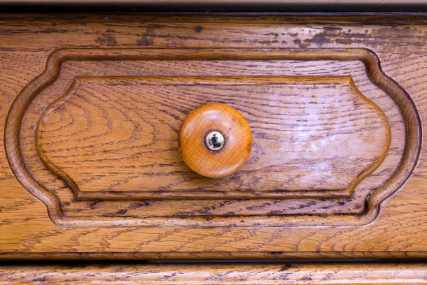 Detailed texture of a handle for opening a wooden locker, the locker door is wooden, brown old wood with traces of use. Antique furniture, flat furniture texture.