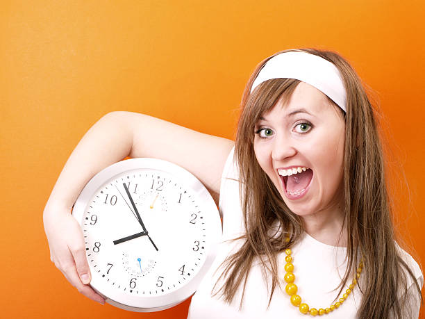 Happy woman with clock in hand stock photo