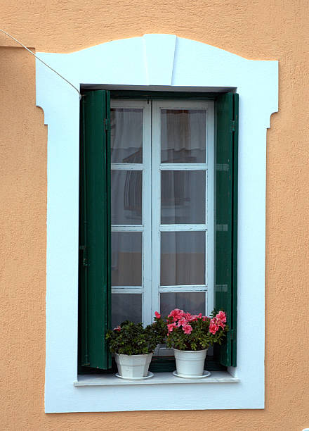 Skopelos island, Greece WIndow with white panes, green shutters, anA'd pots of flowers alintal stock pictures, royalty-free photos & images