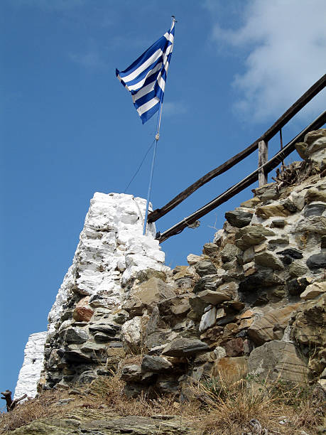 Greek flag Greek flag flowing on top of a cliff alintal stock pictures, royalty-free photos & images