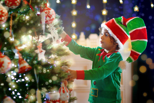 istock Child decorating Christmas tree. Kid on Xmas eve. 1449646393