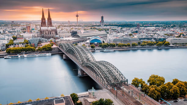 istock Cologne Aerial view with trains move on a bridge over the Rhine River on which cargo barges and passenger ships ply. Majestic Cologne Cathedral in the background 1449647865