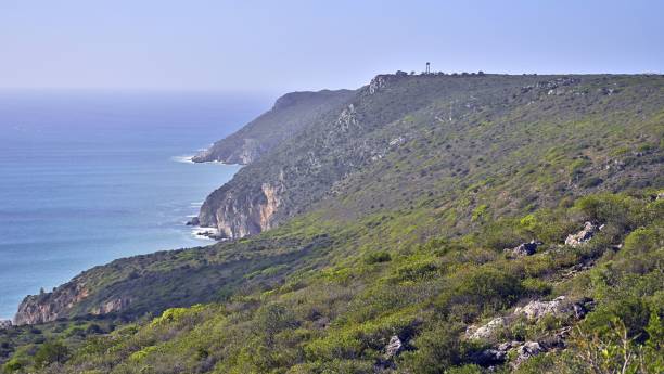 istock Impressive rocky cliffs covered with greenery on Atlantic Ocean coast in Portugal under blue sky 1449648051