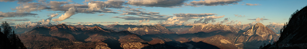 multiple close-up shots composition showing a wide natural mountain landscape in the Carnic Alps seen from above at sunset during autumn season while clouds travel in the clear sky