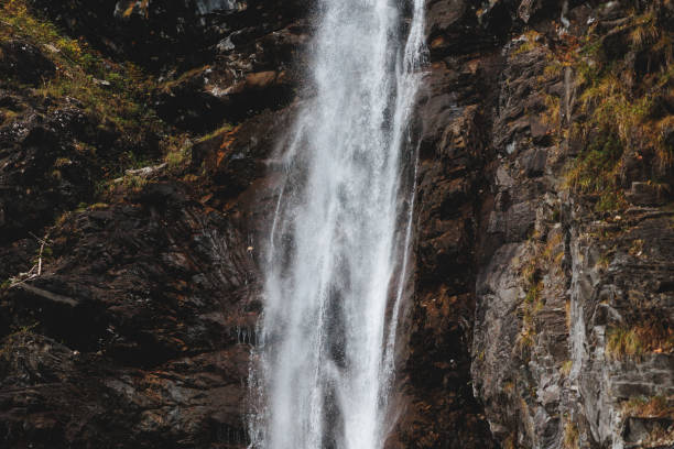 istock waters of a waterfall falling down a rocky wall in the mountains 1449650686