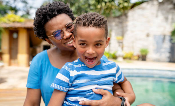 istock Little boy laughing while sitting with his mother outside 1449654444