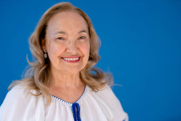 istock Smiling senior woman standing against a blue background 1449654545