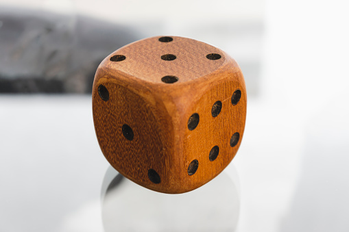 Wood dice looks floating through abstract background, showing number 6, 5 and 3