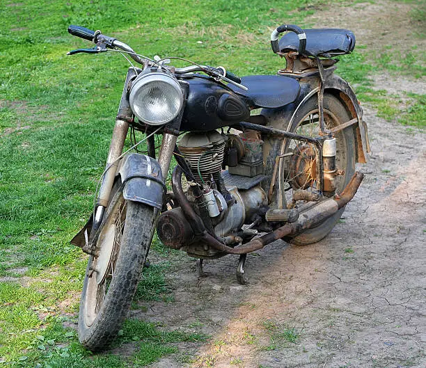 Very old two wheel motorcycle outside on the field 