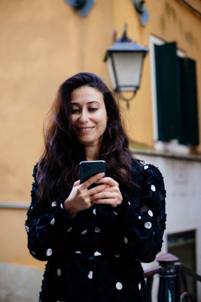 istock Woman texting with smartphone at venice street 1449659230