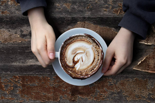 istock woman holding a cup of coffee 1449663206