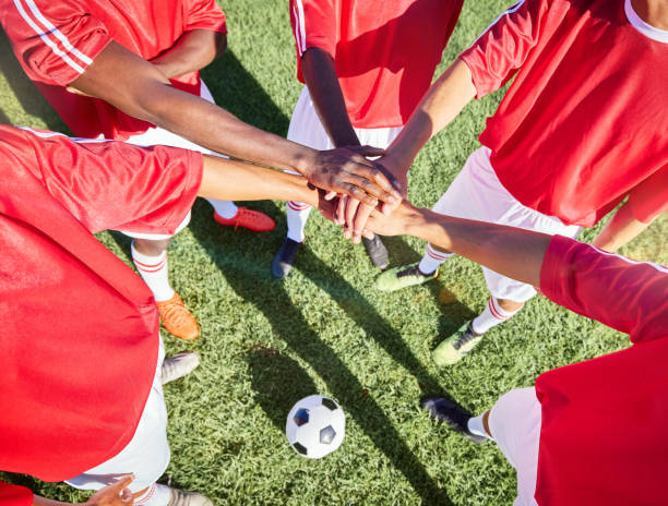 Soccer, team and hand in stack on field for motivation, support and teamwork at game, contest or match. Football, group and soccer player on pitch together with hands for goal, success and sports