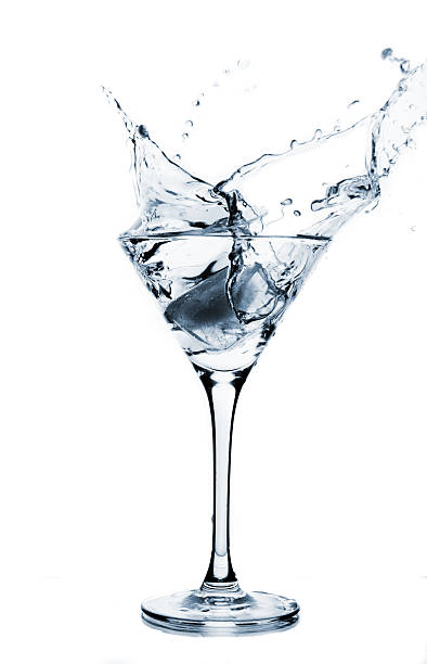 istock Clear liquid splashing into a martini glass 144966541