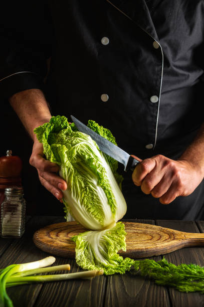 istock Napa cabbage salad preparation. Chef while working in the restaurant kitchen. Diet breakfast or dinner idea 1449673369