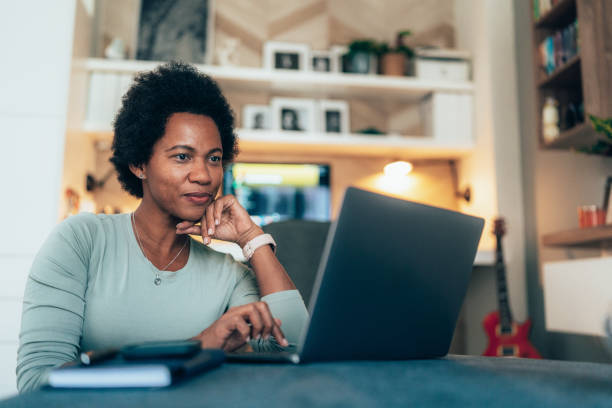 Woman with laptop at home stock photo
