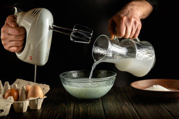 istock The chef prepares a delicious dinner with milk and eggs in the kitchen using an electric hand mixer. The cook pours the poloko into a deep plate. Delicious recipe menu for hotel. 1449675060