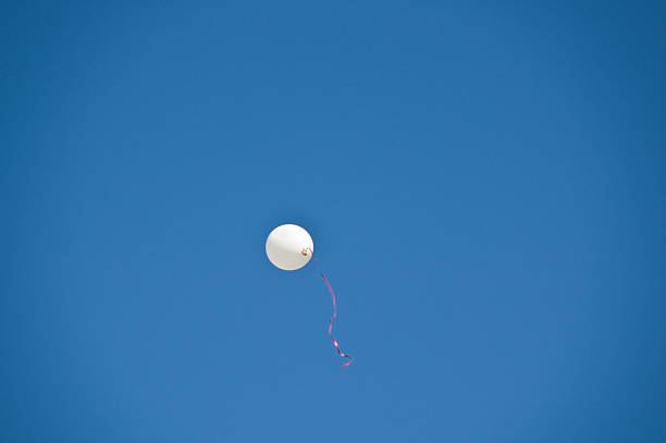 Balão em branco com fita vermelha no céu azul - foto de acervo
