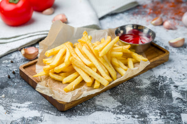 istock french fries on board with ketchup on grey table 1449681571