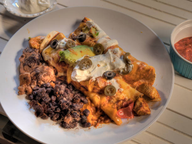 istock Top View of Chicken Enchiladas on white Natural wood surface 1449682327