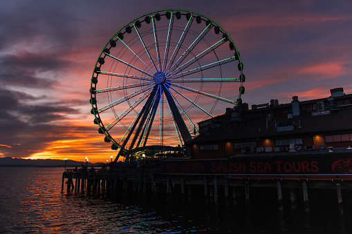 Seattle, USA - Aug 21, 2022: Sunset over Elliott Bay on the waterfront with the Seattle Great Wheel.