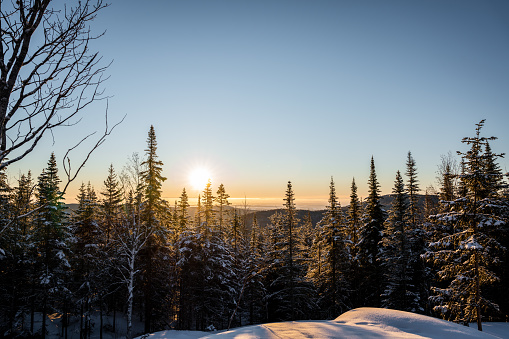 Mountain range and forest near Lac-Beauport city in Quebec during a cold sunrise of winter.