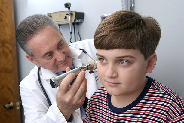 istock Mature hispanic physician examing young boy in doctor office 144969087