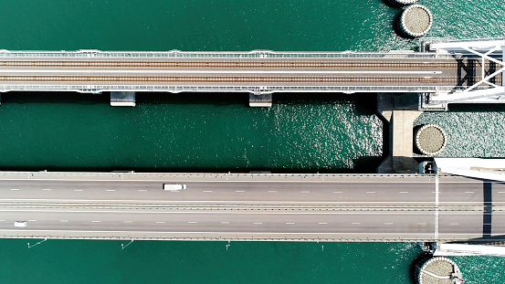 Summer view from a helicopter. Action. A huge bridge for moving cars made high above the sea and the blue daytime sky. High quality 4k footage