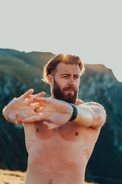 istock Male athlete doing arm stretching exercise on top of a mountain 1449696955