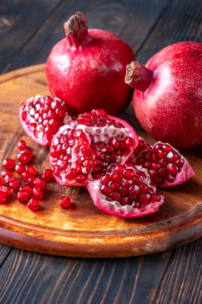 istock Fresh pomegranates on the wooden table 1449701891