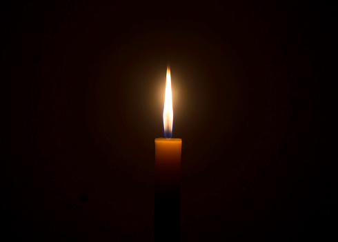 Close-up of burning candle in the dark