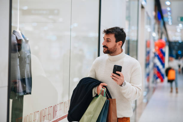 istock Handsome young man window shopping in a mall 1449703959
