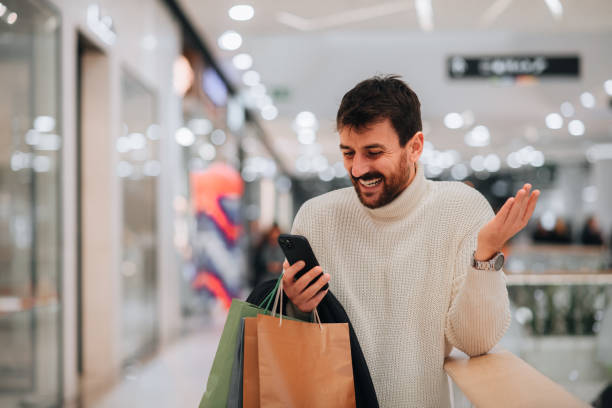 Attractive young man on a video call while shopping at the mall