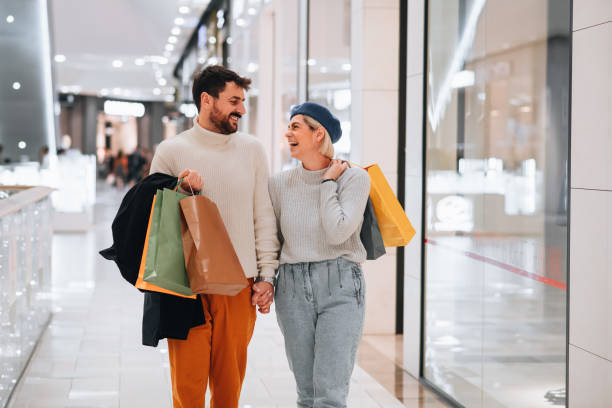 casal fazendo compras e de mãos dadas - store sale shopping mall window - fotografias e filmes do acervo