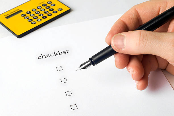 istock hand filling in Checklist with pen 144970764