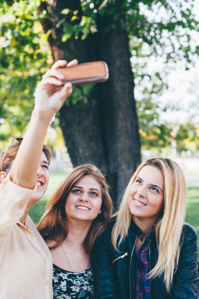 istock Happy girls making selfie in the park 1449708175