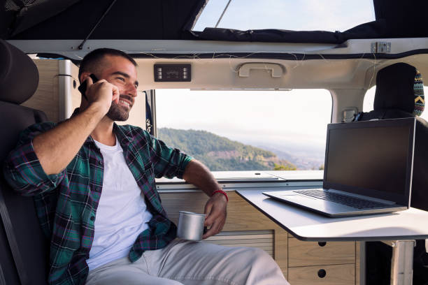istock man inside his camper van talking on mobile phone 1449718180