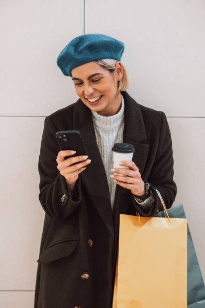 istock Beautiful young woman having a coffee break from shopping 1449729144